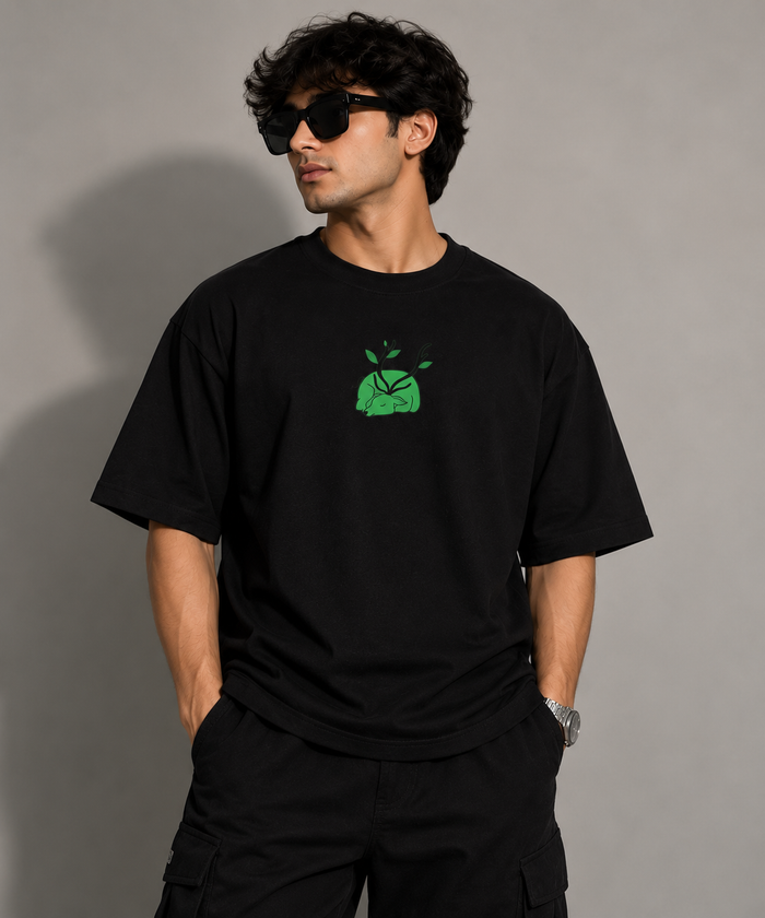 Model wearing the Selinx IN FRAME black oversized tee, front view with green chest graphic